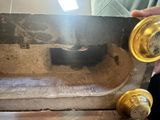 a person that is holding a piece of wood in front of a sink