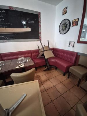 tables and chairs in a restaurant with a chalkboard on the wall