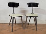 two black and white chairs sitting next to each other on a hard wood floor