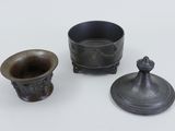 three small metal objects are sitting on a white surface
