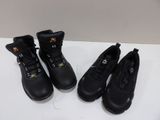 three pairs of black work boots are lined up on a table
