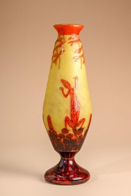 a yellow vase with a red design on it