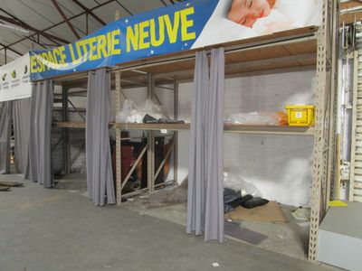 une photo d'un magasin avec une grande enseigne accrochée au mur