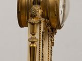 a clock on a stand with a bird on top of it