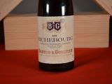 a bottle of wine sitting on a table next to a wooden box