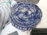 a blue and white yarn on a table next to a book