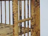 a small bed made out of bamboo sticks on a white surface