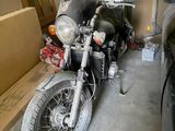 a motorcycle that is parked in a garage next to a car