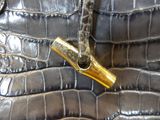 a close up of a purse that has a gold bullet on it