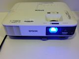 a white projector with a blue light on top of it