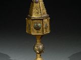 une coupe en or richement décorée, surmontée d'une horloge