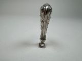 a silver object that is sitting on a white surface