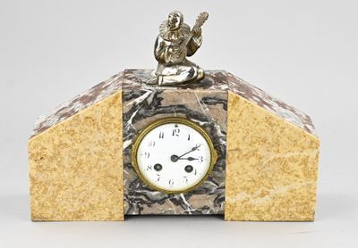 a small clock with a statue on top of it