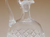 une carafe en verre transparent posée sur une surface blanche