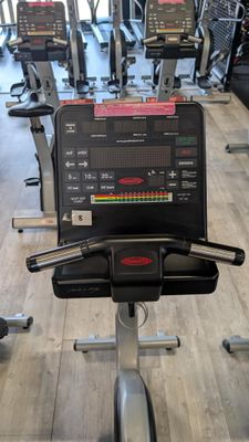 a row of stationary exercise bikes in a gym
