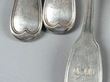 four silver spoons and a spoon with a handle on a table