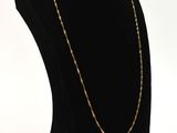 a black mannequin with a gold chain on a white background