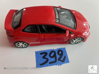 une petite voiture rouge posée sur une table, avec une étiquette de prix