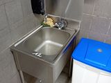 a sink and trash can in a public restroom