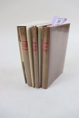 trois livres sont empilés sur une surface blanche
