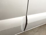 a close up of a white car with a broken door handle