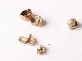plusieurs pièces d'or sont disposées sur une surface blanche