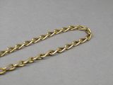 a close up of a gold chain on a gray surface