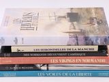 plusieurs livres empilés sur une surface blanche