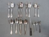 a lot of silver spoons and forks laid out on a table