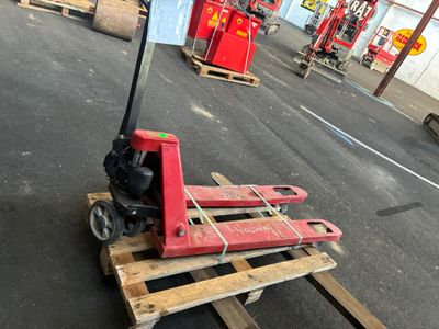 un cariste assis sur une palette dans un entrepôt