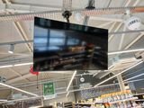 un grand téléviseur suspendu au plafond dans une épicerie