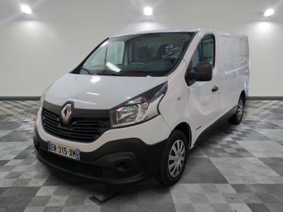 la camionnette blanche est garée sur un sol en damier dans le garage