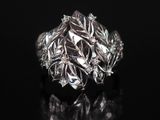 gros plan d'une bague en argent sur une surface noire