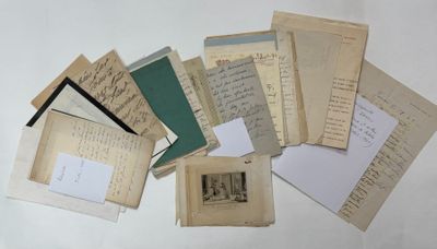 a pile of old letters and papers sitting on a table