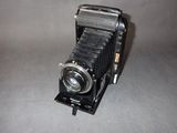 an old camera sitting on a table with a gray background