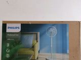 packaging of a philips fan on a white wall with a yellow chair