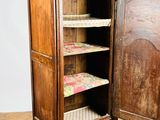 a tall wooden cabinet with a shelf on top of it