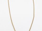 un collier en or orné d'un pendentif en perle sur fond blanc