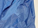 the back of a blue rain jacket with a hood on it