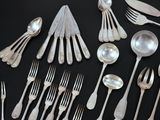 a lot of silverware on a table with spoons and forks