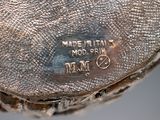 a close up of a silver vase with a label on it