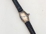 gros plan d'une montre sur une surface blanche avec un bracelet noir