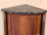 a corner cabinet with a marble top in the corner