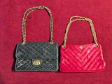 two small bags with chain handles on a red surface