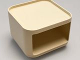 a white box with a beige lid on a gray surface