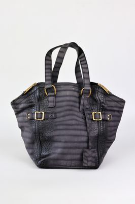Le petit sac fourre-tout est noir et comporte une boucle dorée.