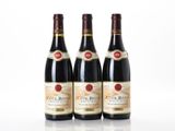 three bottles of red wine sitting next to each other on a white surface
