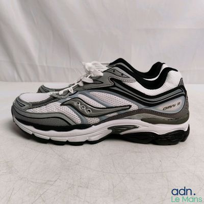 un gros plan sur une paire de chaussures de course posée sur une surface blanche
