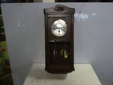 a wooden clock sitting on top of a white table