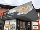 un restaurant avec une grande enseigne sur la façade où l'on peut lire « Le Vietnam »